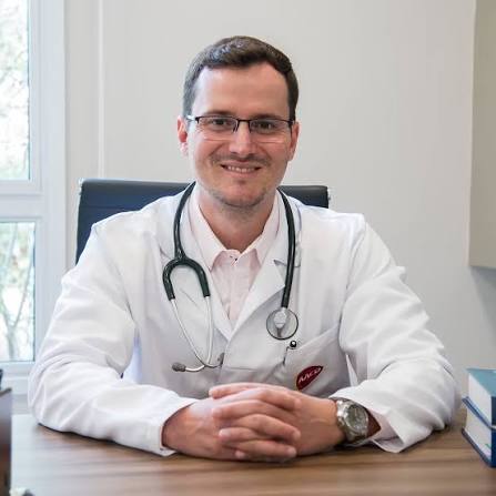Dr. Pedro Tovo usando jaleco branco e estetoscópio.