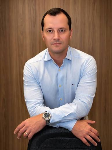 Dr. Pedro Tovo sentado, usando camisa azul clara.